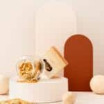 Słoik i opakowanie z ekologicznym brokatem stożkowym Stardust na białym tle z dekoracyjnymi kulami