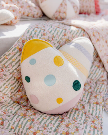 Kolorowa poduszka w kształcie serca z kropkami na patchworkowym kocu z motywem kwiatów