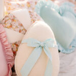 Poduszki dekoracyjne na kanapie w pastelowych kolorach, z sercem i kokardą w kratkę