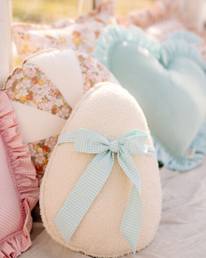 Poduszki dekoracyjne na kanapie w pastelowych kolorach, z sercem i kokardą w kratkę