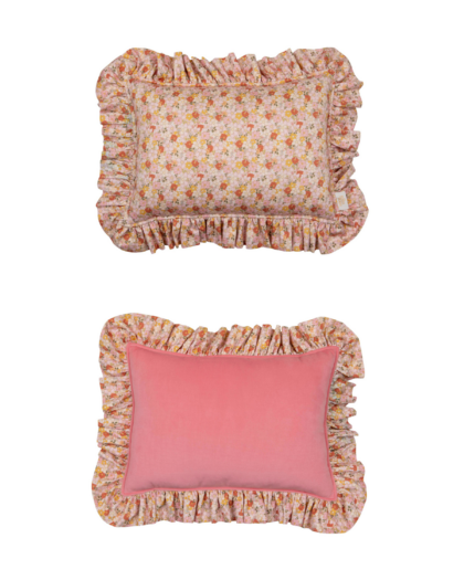 Dwa ozdobne prostokątne poduszki z falbanami, jedna w wzór kwiatowy, druga różowa z kwiatowym brzegiem.