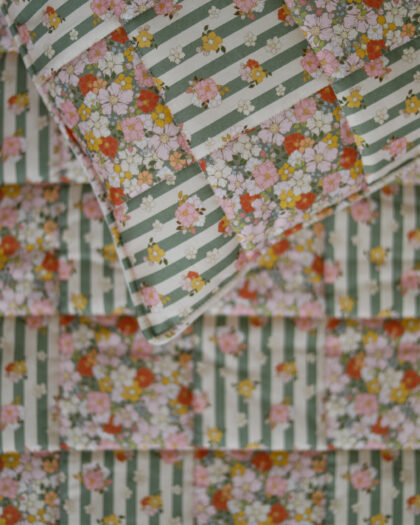 Zbliżenie na pikowaną tkaninę w kwiatowy wzór z zielono-białymi paskami