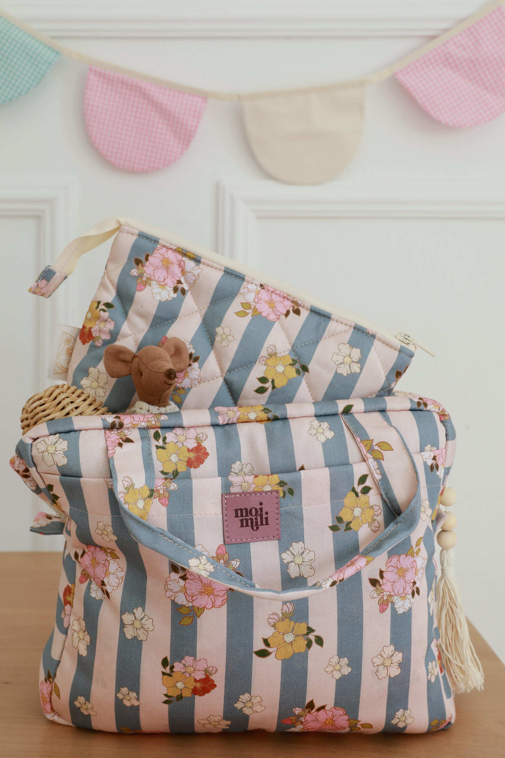 Torba w pasy niebiesko-różowe z motywem kwiatowym, z małą pluszową myszką i plecionym elementem